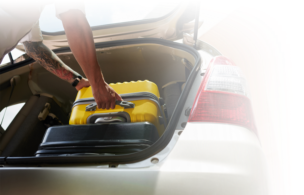 A suitcase being loaded into a car