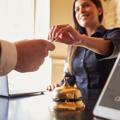 A person handing a credit card to another person.